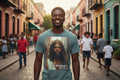 Man wearing a t-shirt with a graphic design of Jesus with a crown and text, standing on a colorful street.