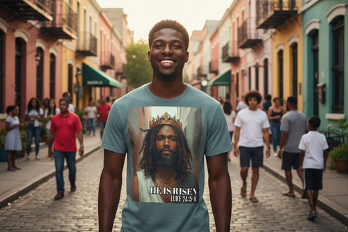 Man wearing a t-shirt with a graphic design of Jesus with a crown and text, standing on a colorful street.
