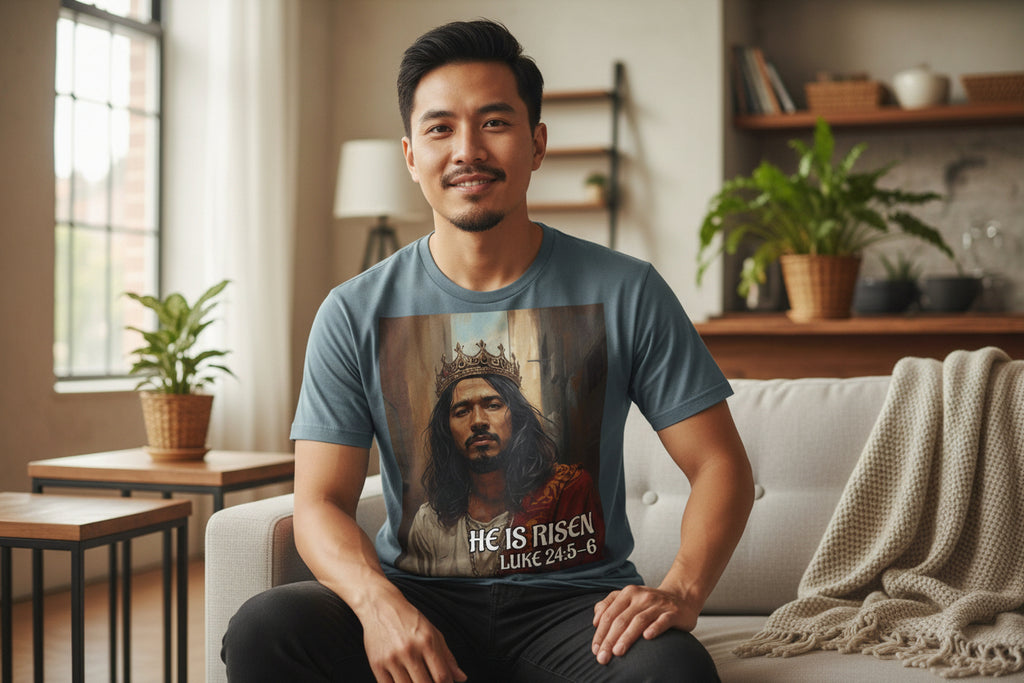 Blue t-shirt with a graphic of an Asian Jesus wearing a crown and 'He is Risen' text on a white background