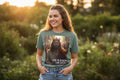 Teal t-shirt with a graphic of a Caucasian Jesus in a crown and 'He is Risen' text on a white background