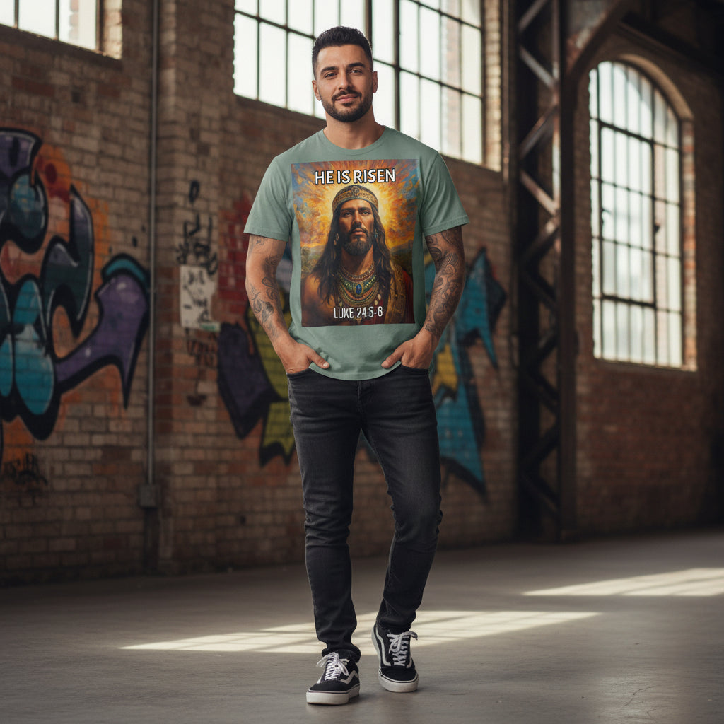 Teal t-shirt with a graphic of an Indigenous Jesus with a crown and 'He is Risen' text on a white background