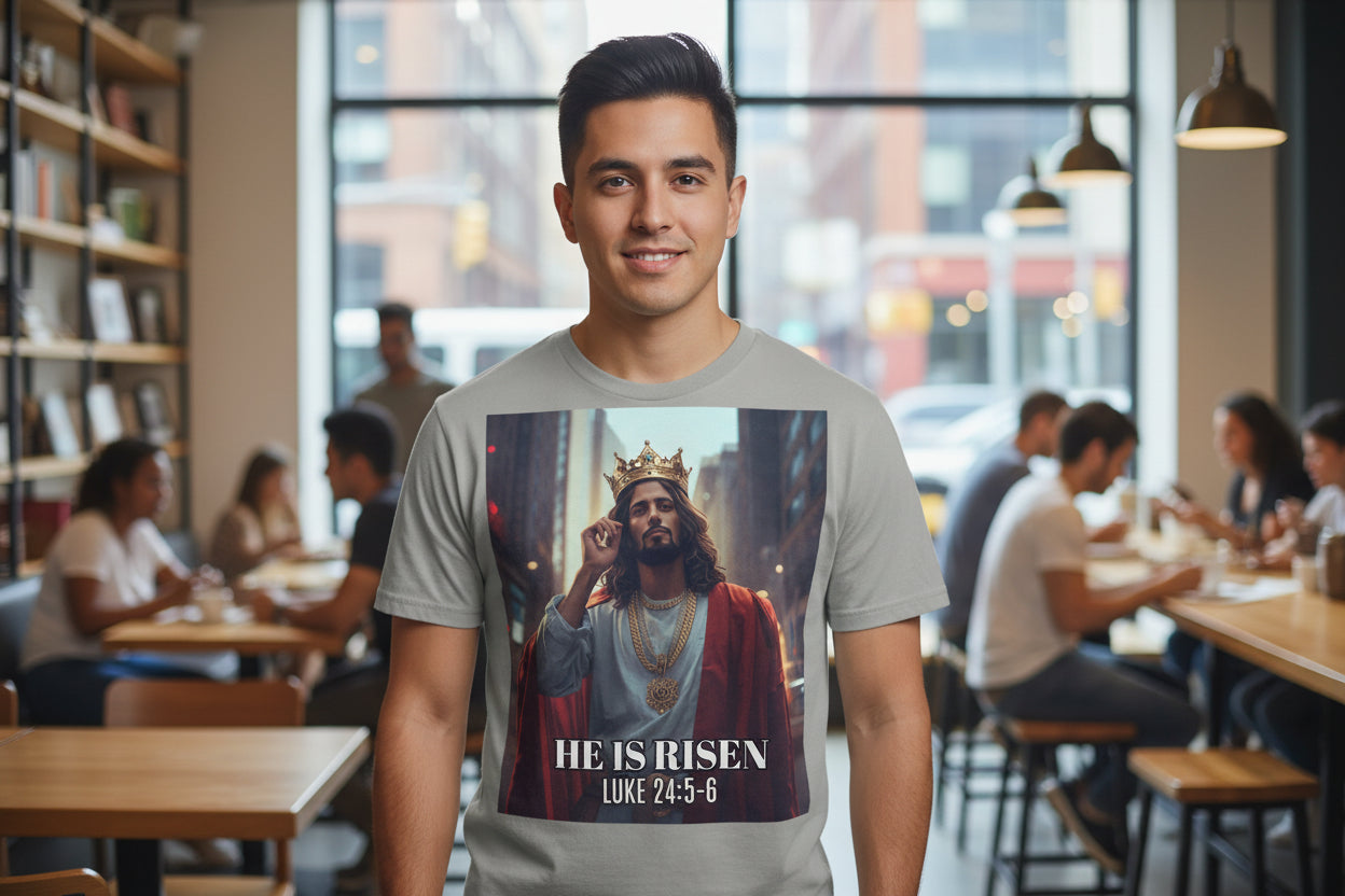 Man wearing a t-shirt with a graphic of a Latino Jesus in a crown and 'He is Risen' text in a casual setting.