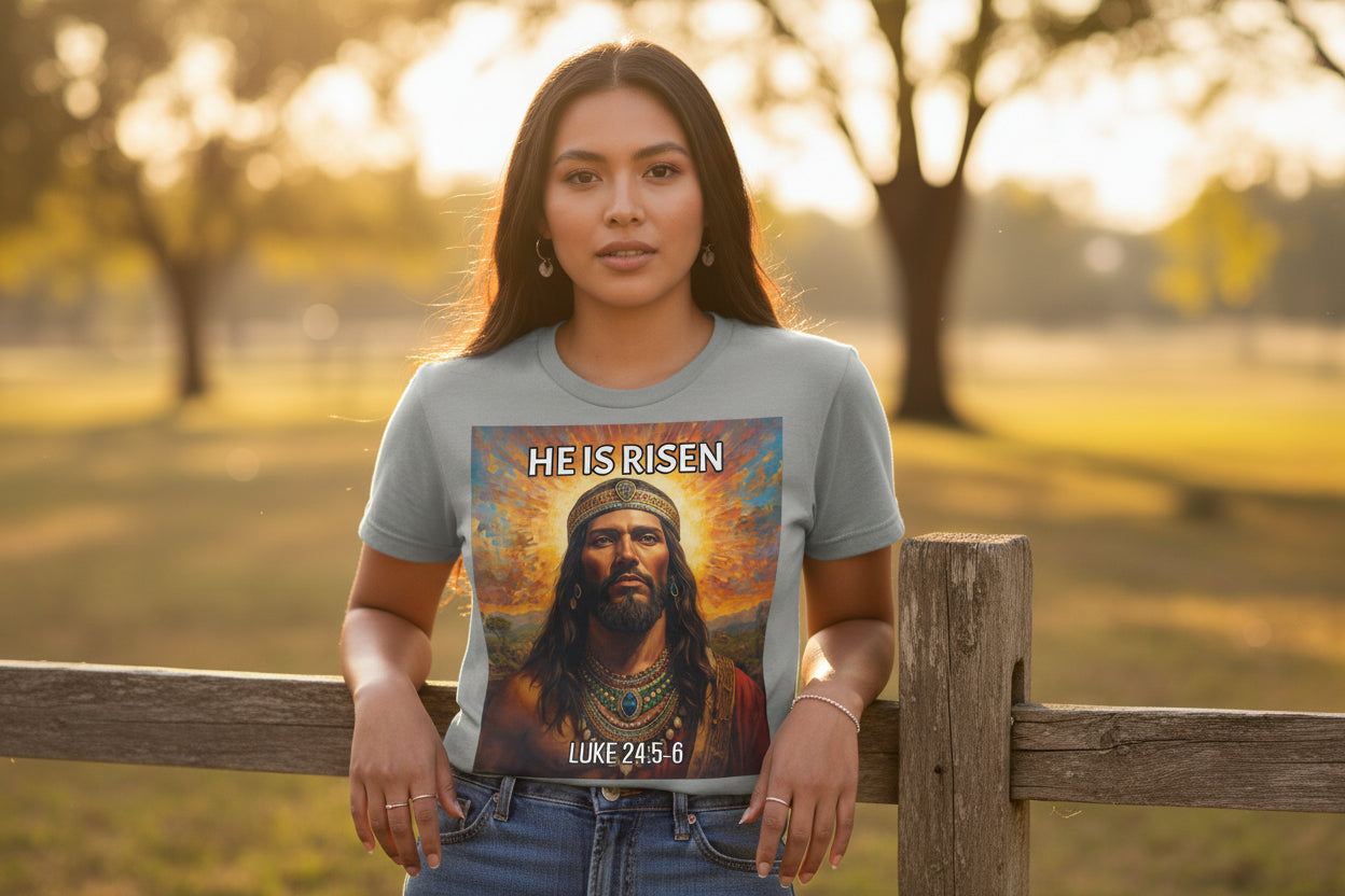 Gray t-shirt with a graphic of an Indigenous Jesus with a crown and 'He is Risen' text on a white background