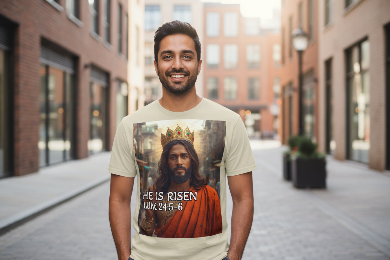 T-shirt with a graphic of an Indian Jesus in a crown and robe, with 'He is Risen' text on a beige background.