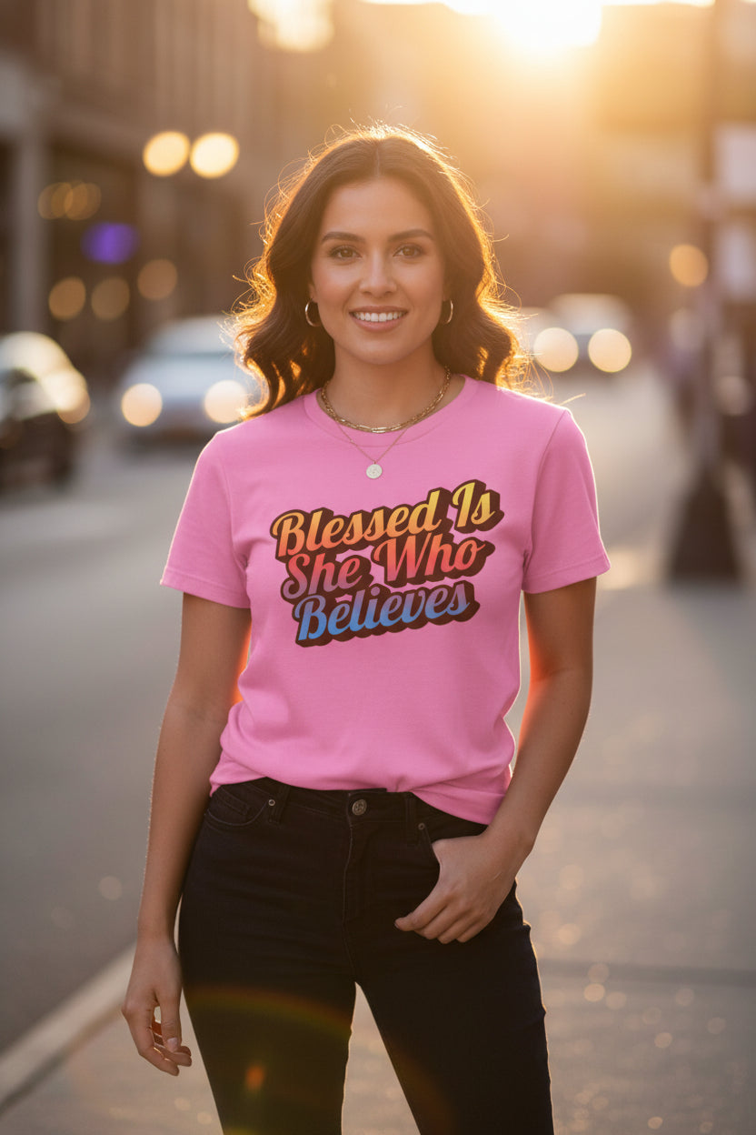 Woman wearing a pink t-shirt with a motivational quote on a city street.